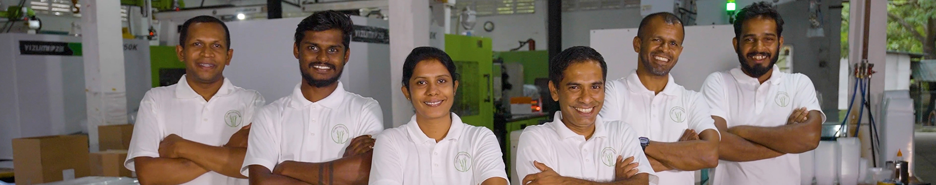 A team of workers positioned in a factory, showcasing a collaborative environment with industrial elements in the background